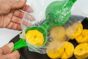 Using a lemon squeezer to make plantain cups photo