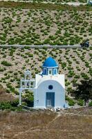 viñedos y el santo trinidad Iglesia situado en acrotiri pueblo en el santorini isla foto