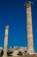 Ruins of the Temple of Olympian Zeus also known as the Olympieion and the Acropolis at the center of the Athens city in Greece photo