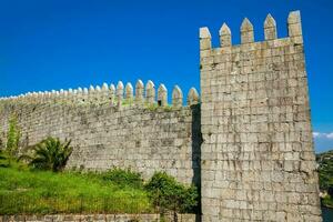 Detail of the Fernandine Walls of Porto located next to the Dom Luis I Bridge in a beautiful sunny day photo