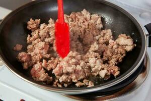 preparación de suelo carne de vaca con el tradicional Colombiana hogao o criollo salsa hecho de preparación de el tradicional Colombiana hogao o criollo salsa hecho de cebolla, tomate, pimientos y cilantro. foto