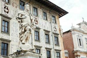 The statue of Cosimo I de Medici in front of Palazzo della Carovana built in 1564 located at the palace in Knights Square in Pisa photo