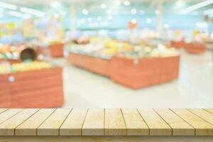 Empty wood table top with supermarket blurred background for product display photo