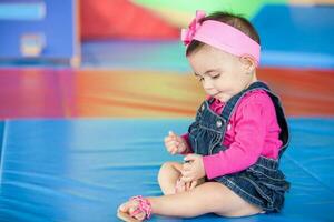 retrato de un hermosa diez meses bebé niña en un vistoso antecedentes. temprano estímulo para niños pequeños concepto. foto