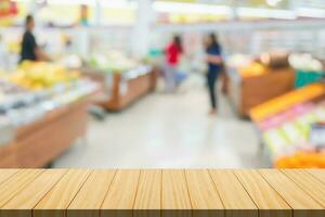 Empty wood table top with supermarket blurred background for product display photo