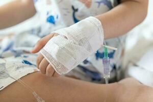 Close up child hand with saline IV solution in hospital photo