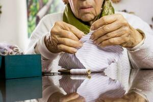 Senior woman sewing a homemade face mask during the Covid 19 pandemic photo