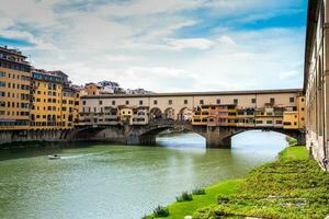 ponte vecchio un medieval Roca enjuta cerrada segmentario arco puente terminado el arno río en florencia foto