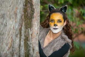 Beautiful young woman wearing a wolf costume. Real family having fun while using costumes of the Little red riding hood tale in Halloween. photo