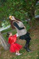 Beautiful girl on little red riding hood costume playing with her mom. Real family having fun while using costumes of the Little red riding hood tale in Halloween. photo