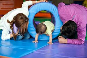 joven padres jugando con su bebé hija. temprano estímulo para niños pequeños concepto. foto