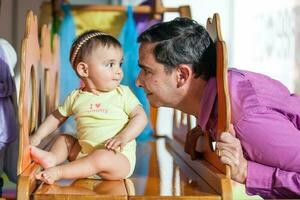 joven padre jugando con su bebé hija. temprano estímulo para niños pequeños concepto. foto