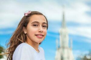 hermosa joven niña a el río bulevar en frente de el famoso gótico Iglesia de la ermita construido en 1602 en el ciudad de cali en Colombia foto