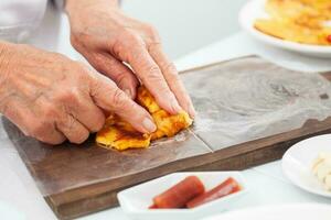 Senior woman preparing a traditional dish from el Valle del Cauca in Colombia called aborrajado photo