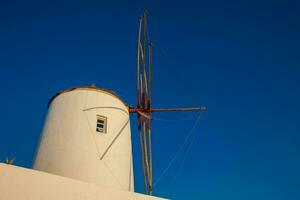 Antique traditional windmills in the city of Oia at Santorini Island photo