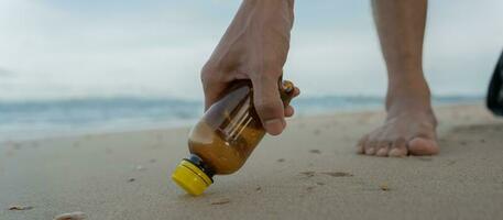 ahorrar agua. los voluntarios recogen basura en la playa y las botellas de plástico son difíciles de descomponer para evitar dañar la vida acuática. tierra, ambiente, planeta verde, reducir el calentamiento global, salvar el mundo foto