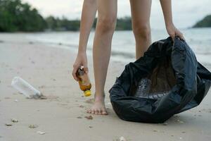 ahorrar agua. los voluntarios recogen basura en la playa y las botellas de plástico son difíciles de descomponer para evitar dañar la vida acuática. tierra, ambiente, planeta verde, reducir el calentamiento global, salvar el mundo foto