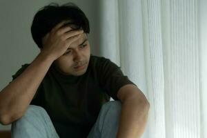 Depression and mental illness. Asian man disappoint, sad after receive bad news. Stressed boy confused with unhappy problem, arguing with girlfriend, cry and worry about unexpected work, down economy. photo