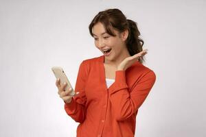 Asian beautiful woman exited surprise face expression . female feels shocked with the phone. exciting smile and happy adorable rejoices. Very enjoy and fun relax time. wow, girl holding smartphone. photo