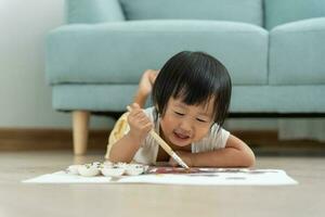 Happy Asia children playing learning paint on paper. Activity, development, IQ, EQ, meditation, brain, muscles, essential skills, family having fun spending time together. Holiday photo