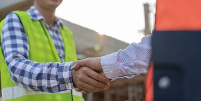 Construction worker team hands shaking greeting start up plan new project contract in office center at construction site, industry ,architecture, partner, teamwork, agreement, property, contacts. photo