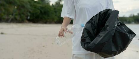 ahorrar agua. los voluntarios recogen basura en la playa y las botellas de plástico son difíciles de descomponer para evitar dañar la vida acuática. tierra, ambiente, planeta verde, reducir el calentamiento global, salvar el mundo foto