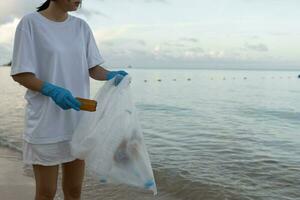 Save water. Volunteer pick up trash garbage at the beach and plastic bottles are difficult decompose prevent harm aquatic life. Earth, Environment, Greening planet, reduce global warming, Save world photo