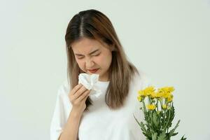 polen alergias, asiático joven mujer estornudos en un pañuelo o soplo en un limpiar, alérgico a salvaje primavera flores o flores durante primavera. alérgico reacción, respiratorio sistema problemas foto