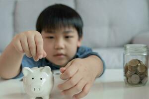 salvar dinero. niños poniendo moneda para cerdito banco para ahorro. poder, finanzas, seguro, inversión, educación, futuro, plan vida, aprender, bancario, familia, salud, salud y accidente seguro. foto