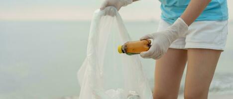 ahorrar agua. los voluntarios recogen basura en la playa y las botellas de plástico son difíciles de descomponer para evitar dañar la vida acuática. tierra, ambiente, planeta verde, reducir el calentamiento global, salvar el mundo foto