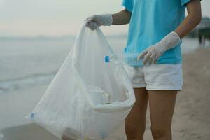 ahorrar agua. los voluntarios recogen basura en la playa y las botellas de plástico son difíciles de descomponer para evitar dañar la vida acuática. tierra, ambiente, planeta verde, reducir el calentamiento global, salvar el mundo foto