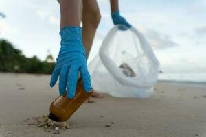 ahorrar agua. los voluntarios recogen basura en la playa y las botellas de plástico son difíciles de descomponer para evitar dañar la vida acuática. tierra, ambiente, planeta verde, reducir el calentamiento global, salvar el mundo foto