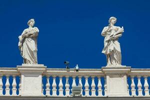Detail of the statues of saints that crown the colonnades of St. Peter Square built on 1667 on the Vatican City photo