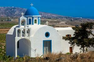 Vineyards and the Holy Trinity Church located in Akrotiri village on the Santorini Island photo