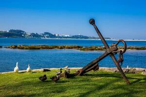 Antique anchor at the Douro River banks near its mouth in Porto city on a beautiful early spring day photo