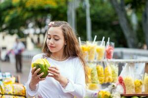 Beautiful young girl at Paseo Bolivar Square in the city of Cali eating tropical fruits in Colombia photo