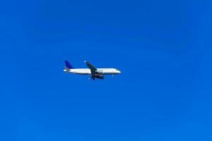 Comercial airplane flying in a beautiful blue sky day photo