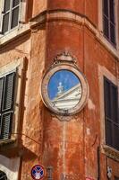 An small piece of the Santa Maria in Aquiro church reflected on a mirror at a corner of Piazza Capranica photo