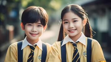 Happy asian boy and girl students in school uniform smiling and looking at camera photo