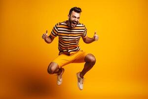 Full length portrait of a happy young man jumping isolated over yellow background photo