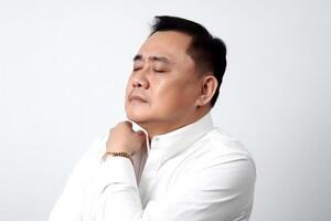 Portrait of a young Asian man with shoulder pain isolated on white background photo