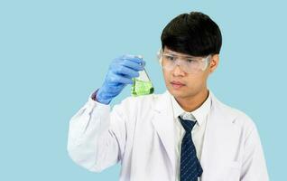 asiático hombre estudiante científico en reactivo mezcla laboratorio en un Ciencias investigación laboratorio con prueba tubos de varios tamaños en el piso en laboratorio química laboratorio azul antecedentes. foto