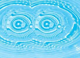 Blue water with ripples on the surface. Defocus blurred transparent blue colored clear calm water surface texture with splashes and bubbles. Water waves with shining pattern texture background. photo