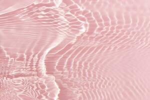 Pink water with ripples on the surface. Defocus blurred transparent white colored clear calm water surface texture with splashes and bubbles. Water waves with shining pattern texture background. photo