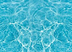 Blue water with ripples on the surface. Defocus blurred transparent blue colored clear calm water surface texture with splashes and bubbles. Water waves with shining pattern texture background. photo