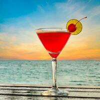 rosado dama, fresa Margarita, sexo en el playa o rosado negroni cócteles en el bar, en el complejo, en el isla, durante el puesta de sol el vaso es adornado con limón y cereza. foto