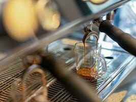 Freshly brewed coffee, espresso, latte, mocha with coffee pouring into a cup in a cafe. photo
