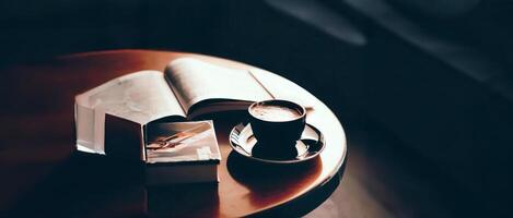 , , Selective focus, a cup of hot coffee on the table with books, magazine, a corner in cafe, retro cozy style, blurred background, spotted light photo