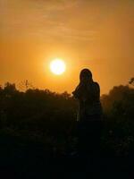 muslimah mujer en el puesta de sol foto