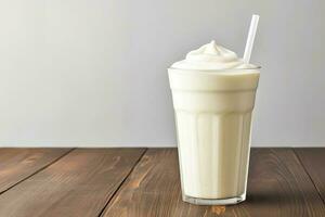 Vanilla cocktail with whipped cream in a tall glass on wooden table. Background with copy space photo